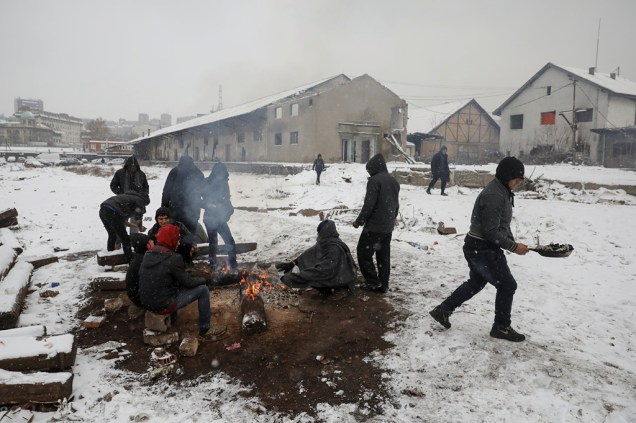 Enquanto a neve cai, refugiados tentam se esquentar em Belgrado. Enquanto a neve cai, refugiados tentam se esquentar em Belgrado.