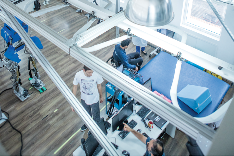 Até o exoesqueleto da Copa está lá de canto, já aposentado, com a pintura riscada e os adesivos usados no pontapé inicial. Em seu lugar estão duas máquinas com pintura azul novinha - a mesma que você viu na abertura desta matéria. Até o exoesqueleto da Copa está lá de canto, já aposentado, com a pintura riscada e os adesivos usados no pontapé inicial. Em seu lugar estão duas máquinas com pintura azul novinha - a mesma que você viu na abertura desta matéria.