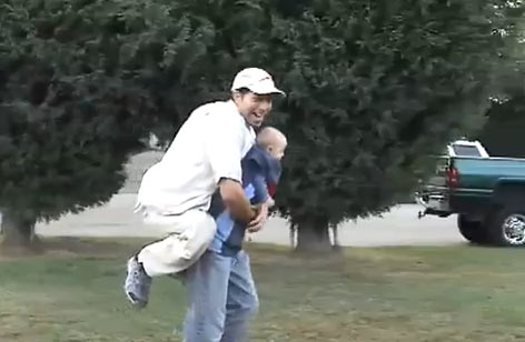 Bebê carrega pai no colo