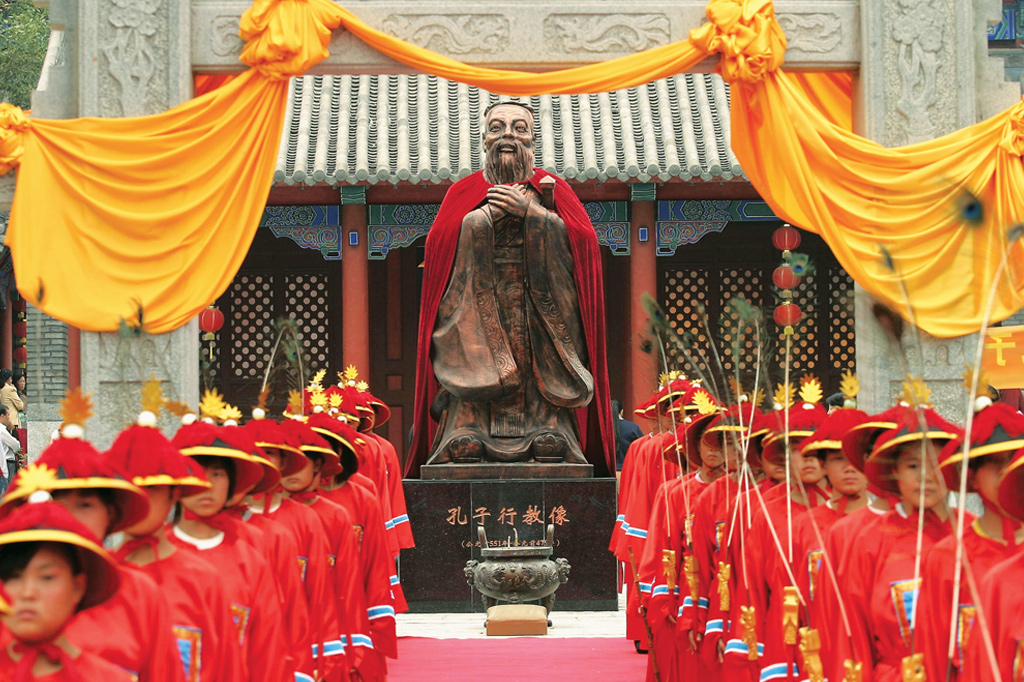 Estudantes vestidos com roupas antigas ficam em frente à estátua de Confúcio (551-479 aC), durante uma cerimônia para adorar o filósofo e educador chinês no Templo Confucionista de Changchun em 25 de setembro de 2005 em Changchun, na província de Jilin, China.