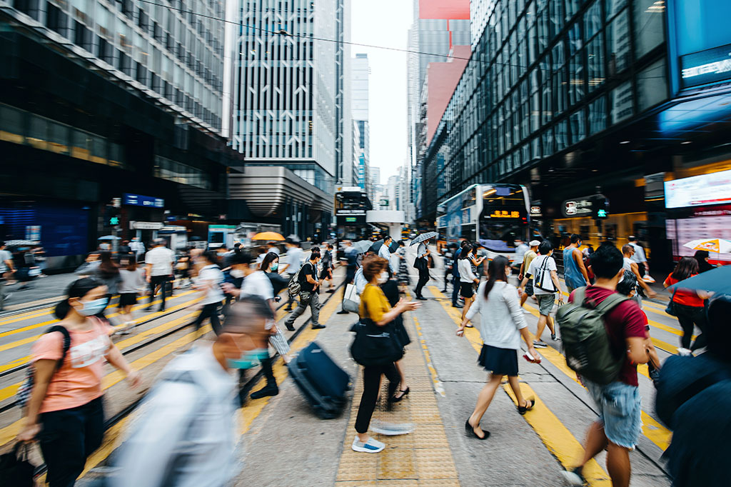 Pessoas andando em Hong Kong utilizando máscaras.
