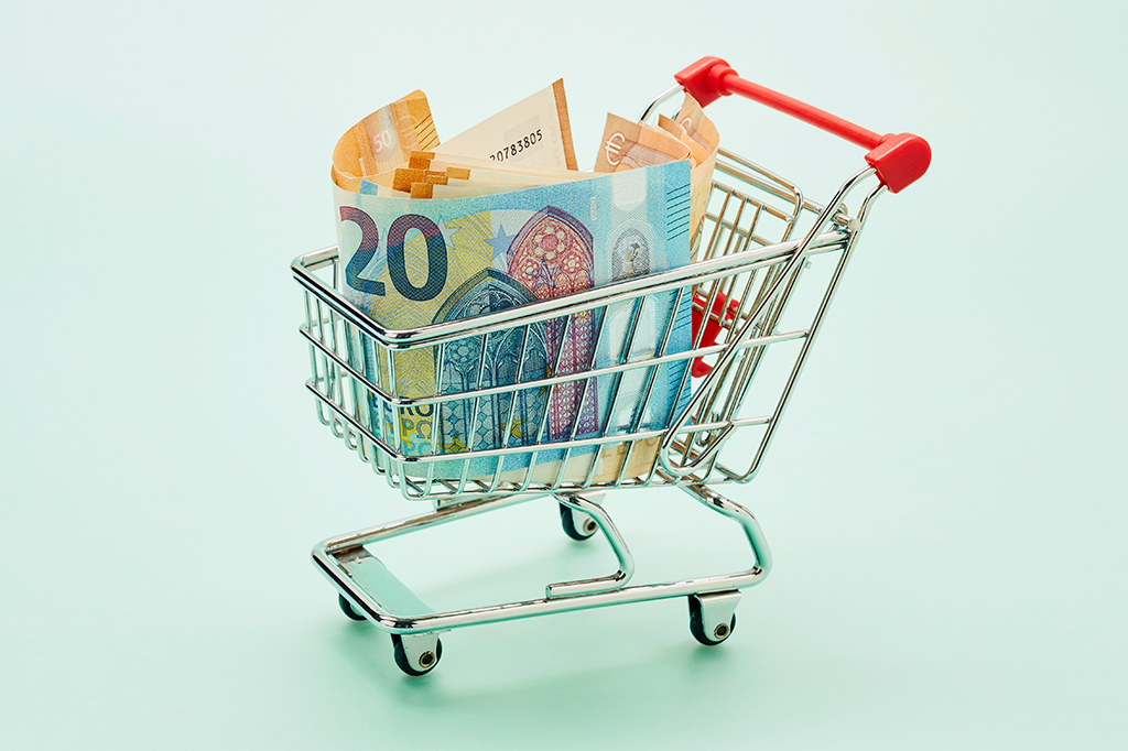 Mini carrinho de mercado com notas de dinheiro dentro.