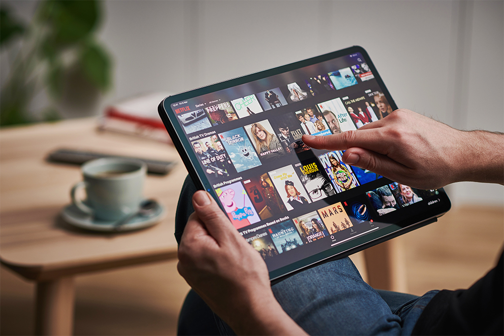 Pessoa navegando por catálogo de aplicativo de streaming de filmes e séries.