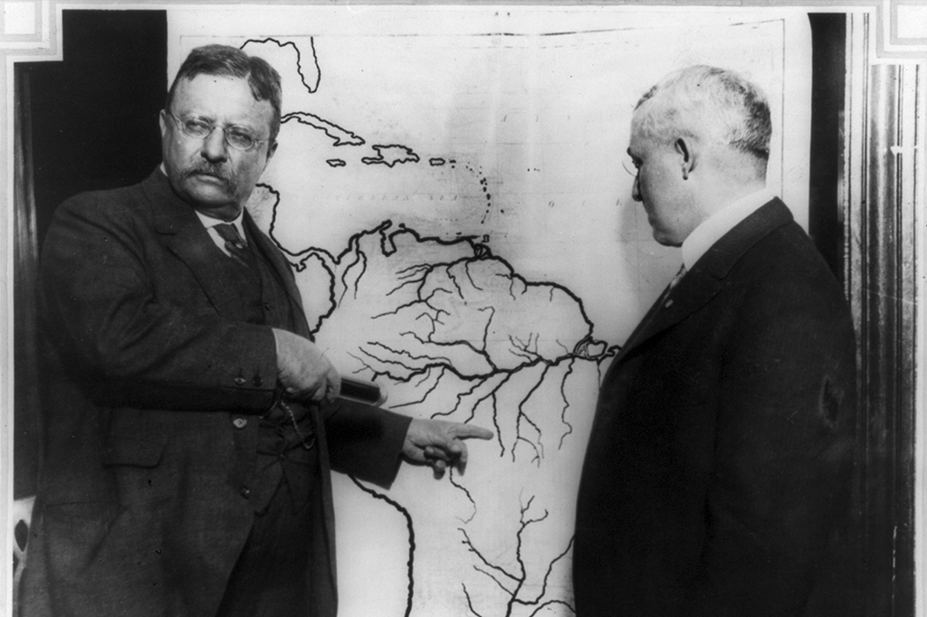 Theodore Roosevelt apontando local no mapa do Brasil durante expedição em Rondônia.