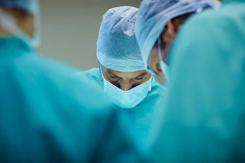 Médicos com máscara realizando cirurgia.