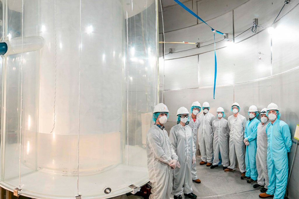 Membros da equipe LUX-ZEPLIN no tanque de água após a instalação do detector externo.