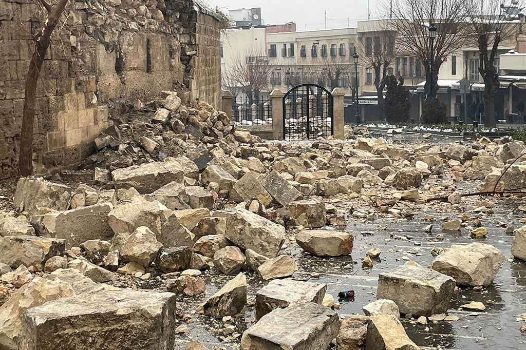 Destroços de pedras pelo chão, detalhando mais o estrago causado pelo terremoto.