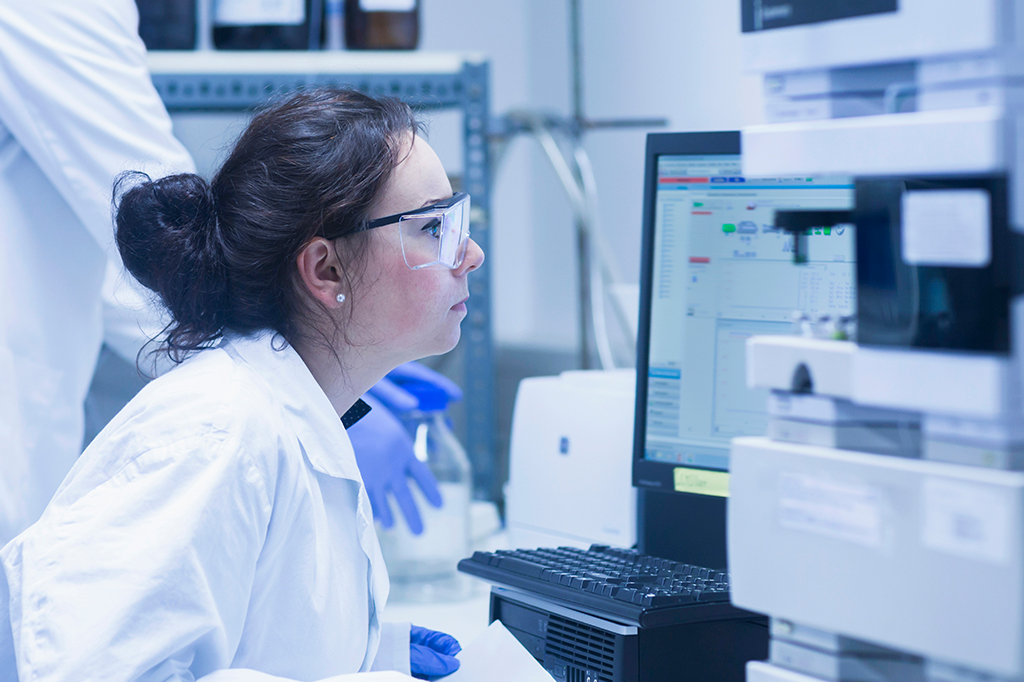 Foto de uma cientista olhando para dados científicos no computador.