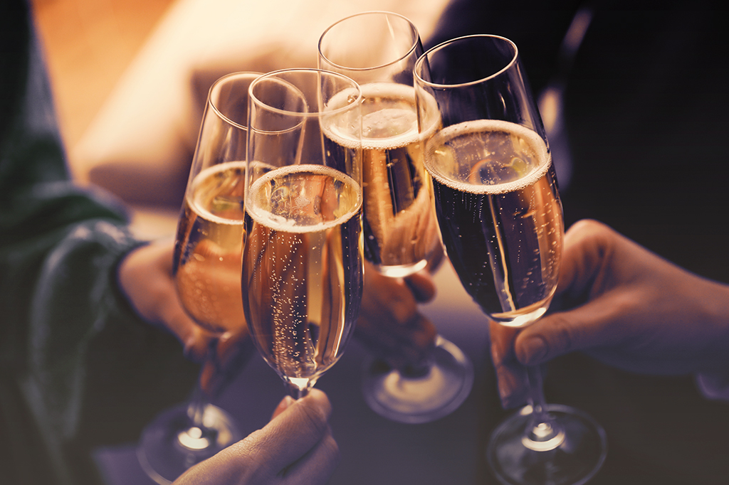Pessoas brindando taças com champagne.