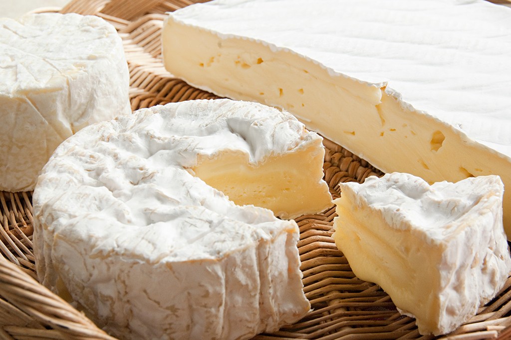 Fotografia dos queijos Brie e Camembert.