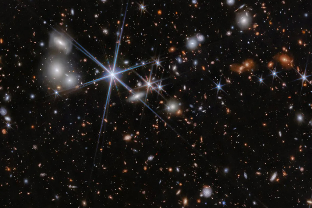 Imagem de Webb mostrando o ambiente do sistema galáctico ZS7, local da colisão de buraco negro mais distante já vista.
