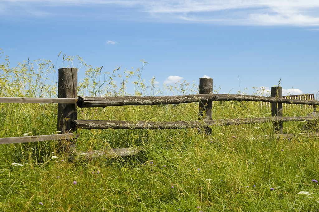 Uma cerca de madeira no meio de um campo.