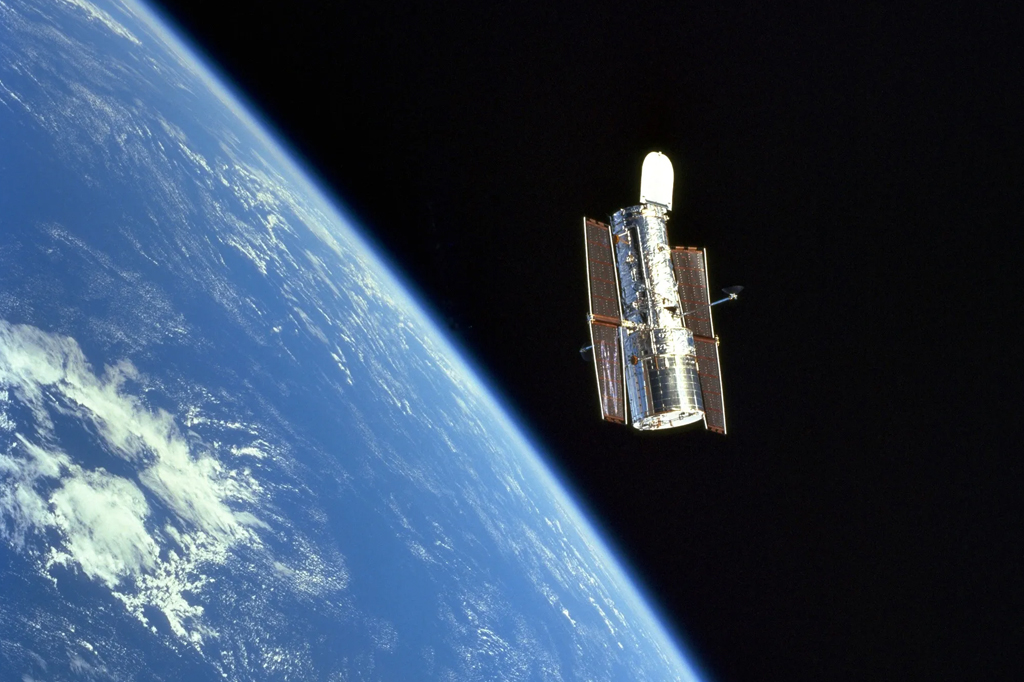 O Telescópio Espacial Hubble flutuando graciosamente acima da Terra.