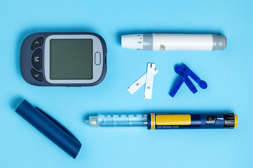 Medidor de açúcar no sangue. Glucometer, caneta de insulina, lanceta e tira de teste em um fundo azul.