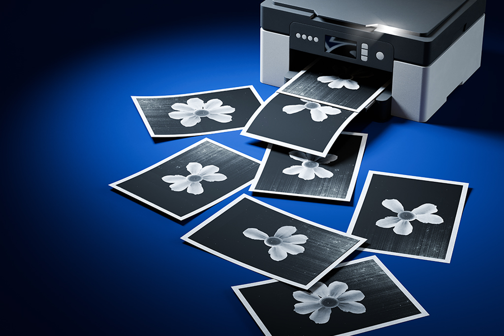 Uma copiadora imprimindo várias folhas com imagens de flores com 