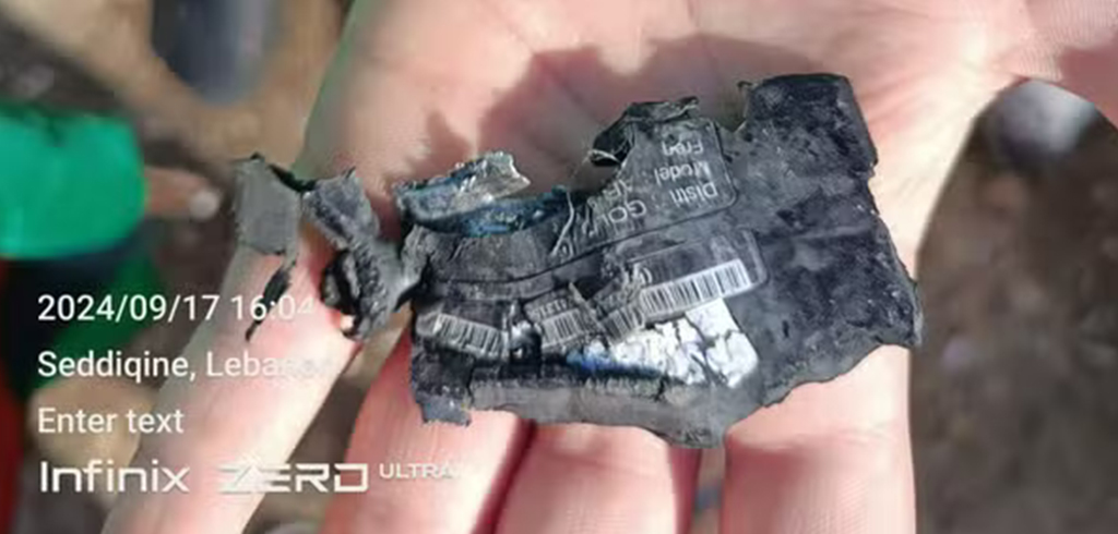 M&atilde;o segurando um pager ap&oacute;s uma explos&atilde;o