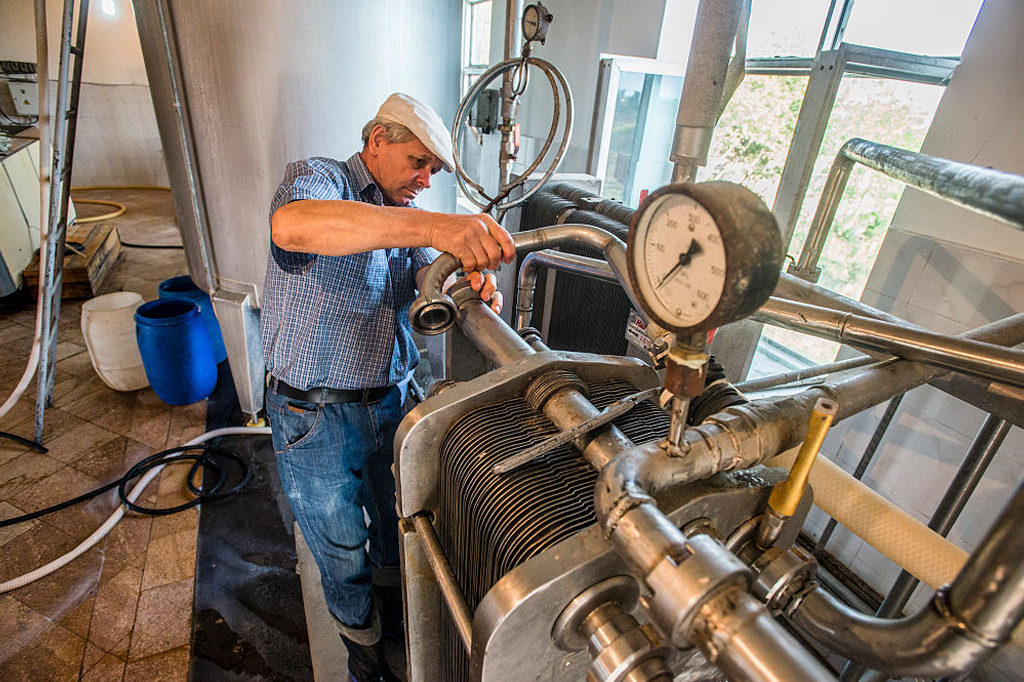 Imagem de um homem operando uma m&aacute;quina de pasteuriza&ccedil;&atilde;o.