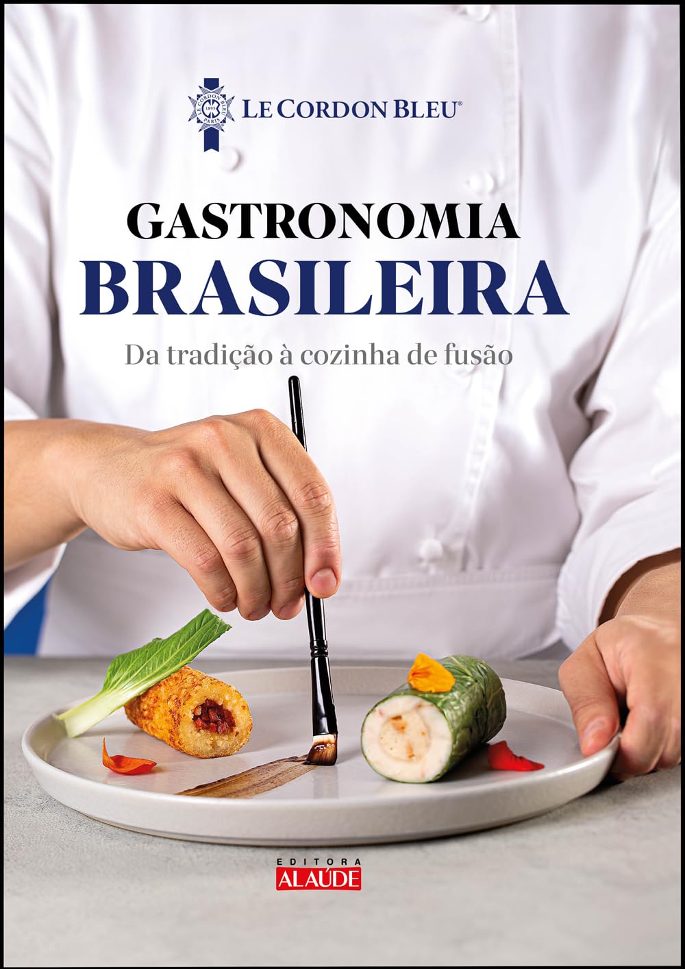 Prato sendo finalizado em cima de uma mesa por um chef de cozinha