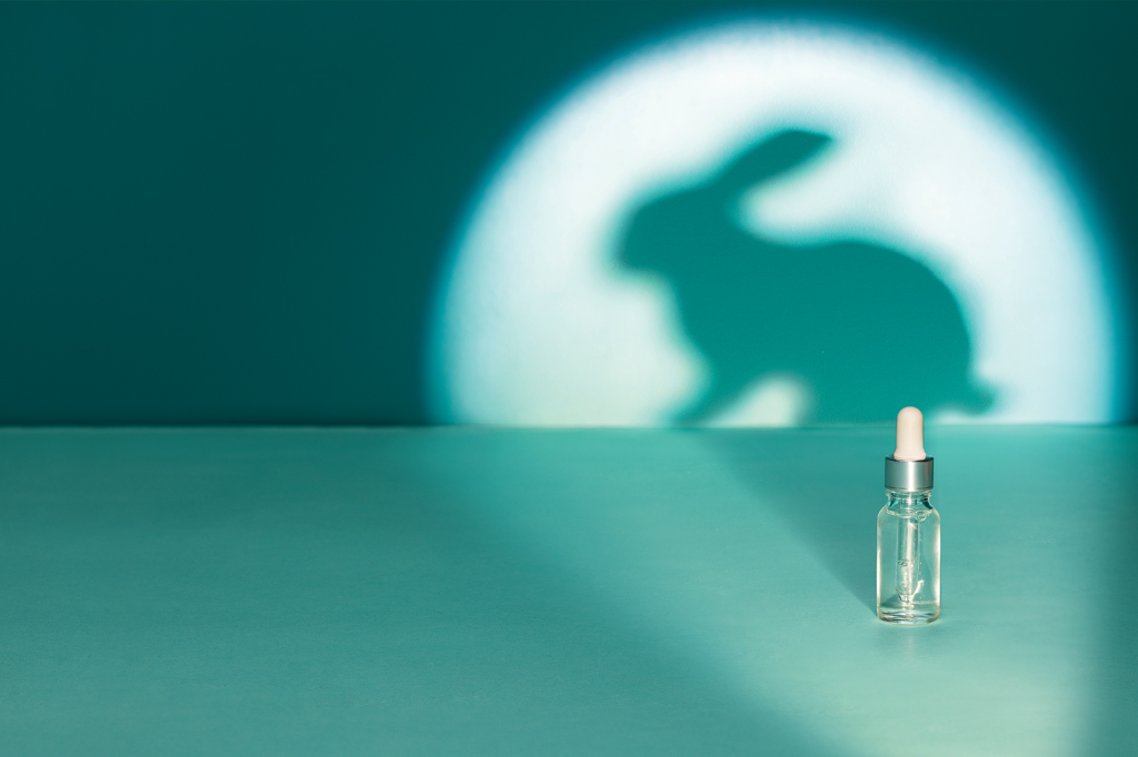 Imagem, de tom esverdeado, projetando a sombra de um coelho na parede. Em primeiro plano, v&ecirc;-se, um frasco conta gotas de vidro.